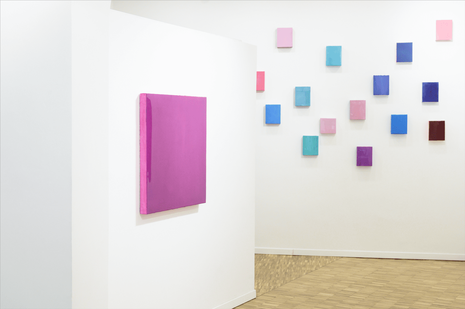 Scopri l'investimento artistico-culturale: grande tela rosa a sinistra, opere blu, viola e rosa a destra.