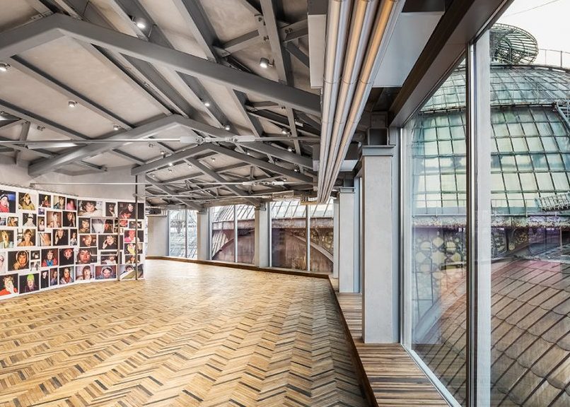 Discover contemporary art: a modern gallery with wooden floor and panoramic windows.